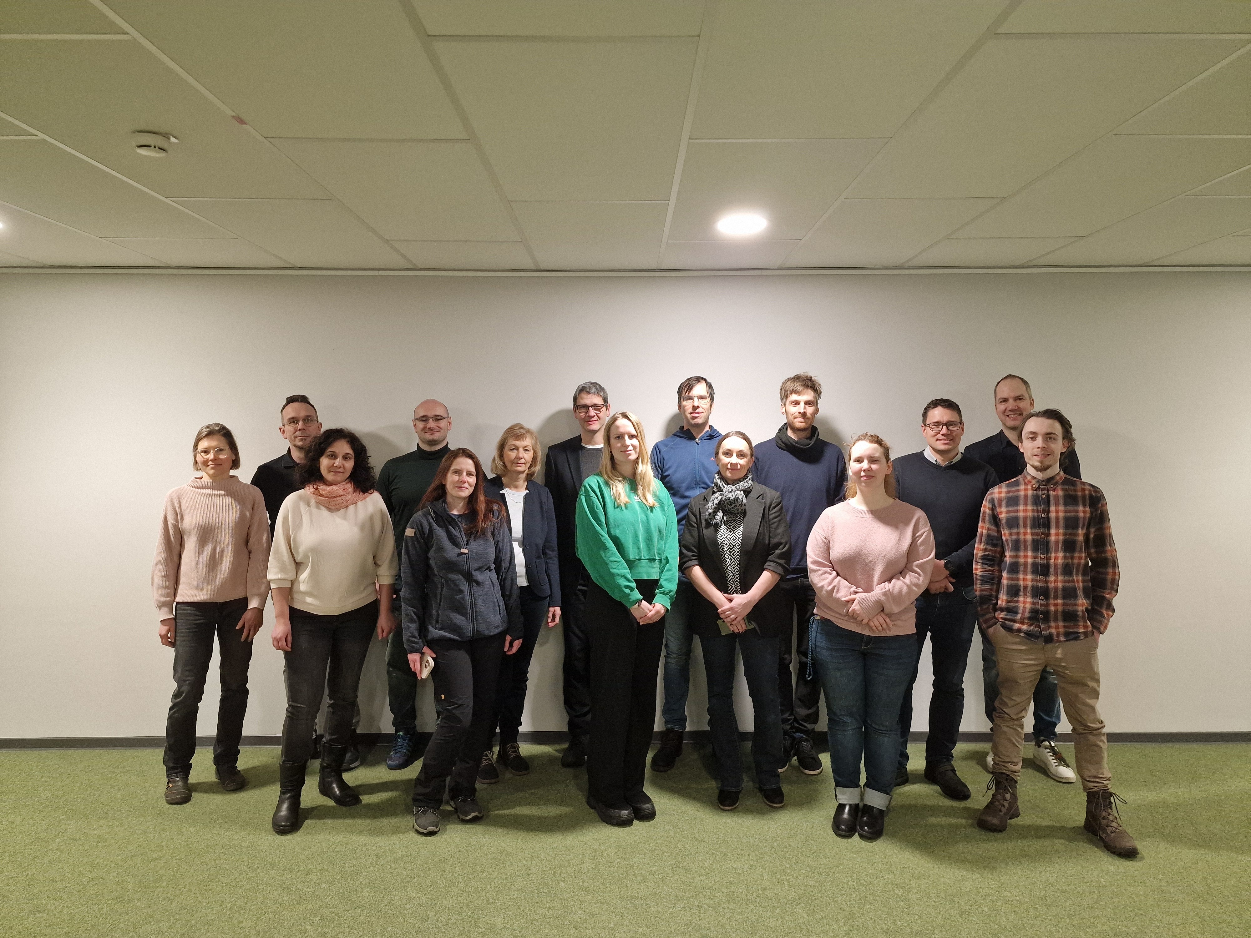 Gruppenfoto der Projektbeteiligten: rund fünfzehn Personen stehen nebeneinander vor einer hellen Wand in einem Seminarraum.